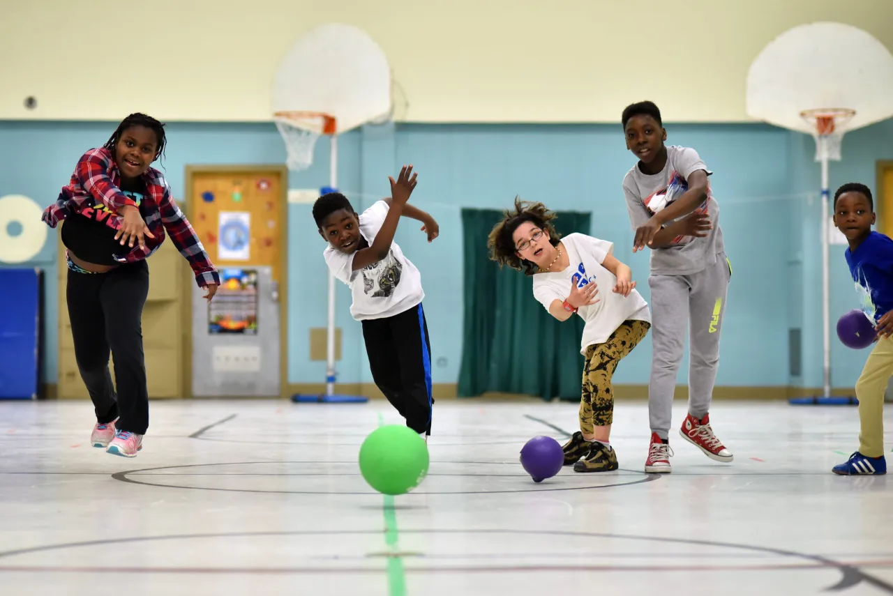 Des enfants qui jouent au ballon après les classes lors d'une activité éducative.