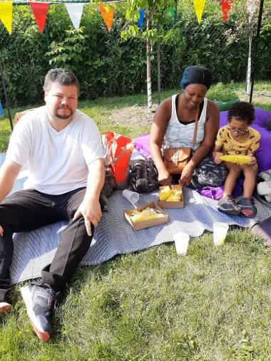 Une famille qui pique-nique dans la cours de la Maison des Familles de Mercier-Est.